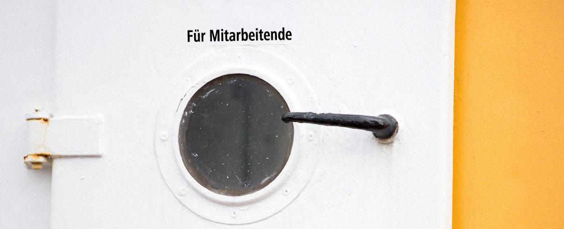 Schiffstür mit Aufschrift: "Für Mitarbeitende"